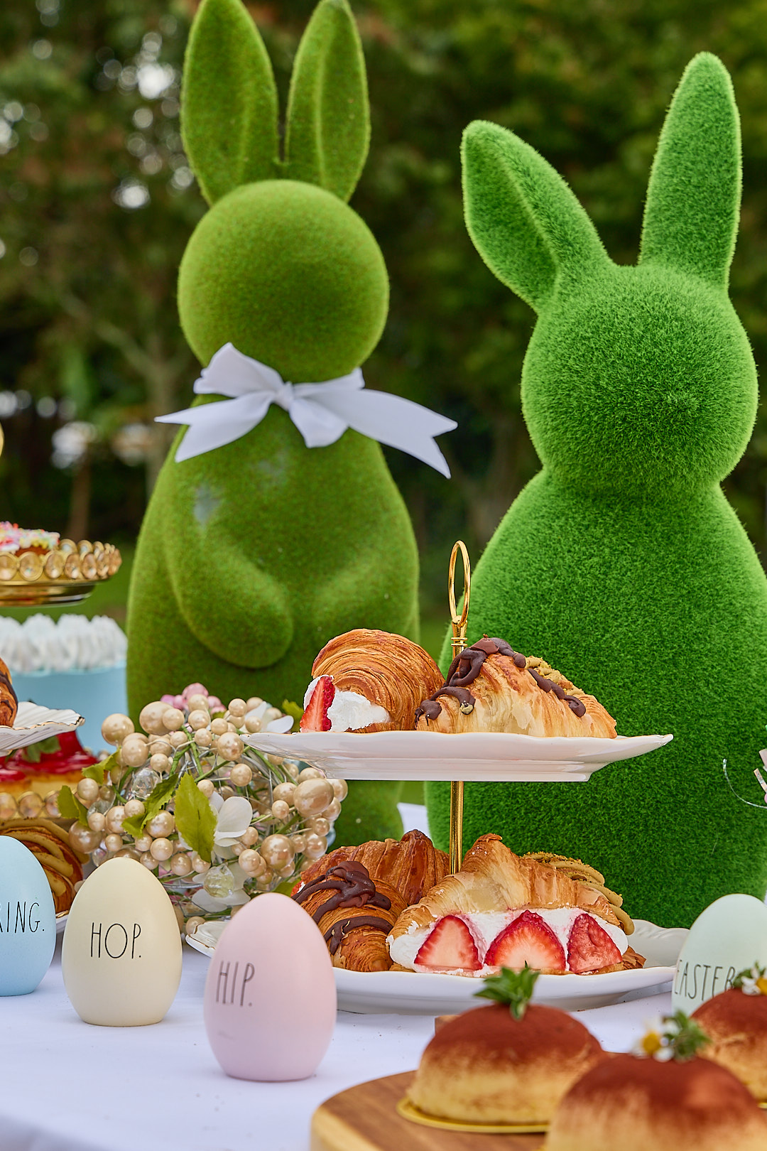 A bright Cuban-Italian catering spread under afternoon sun with cake and pastry plates.