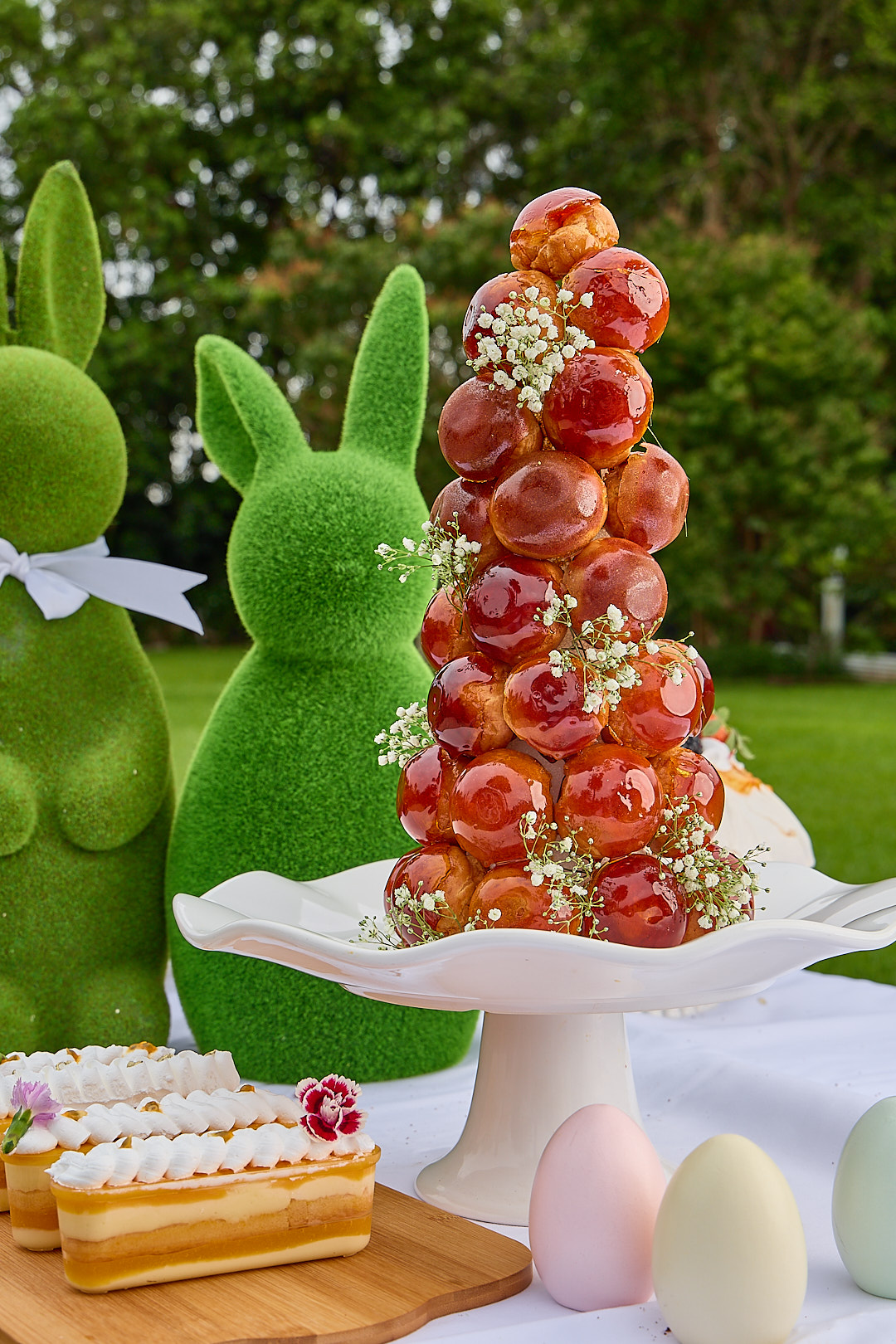 A tall croquembouche of caramel-glazed profiteroles with baby's breath.