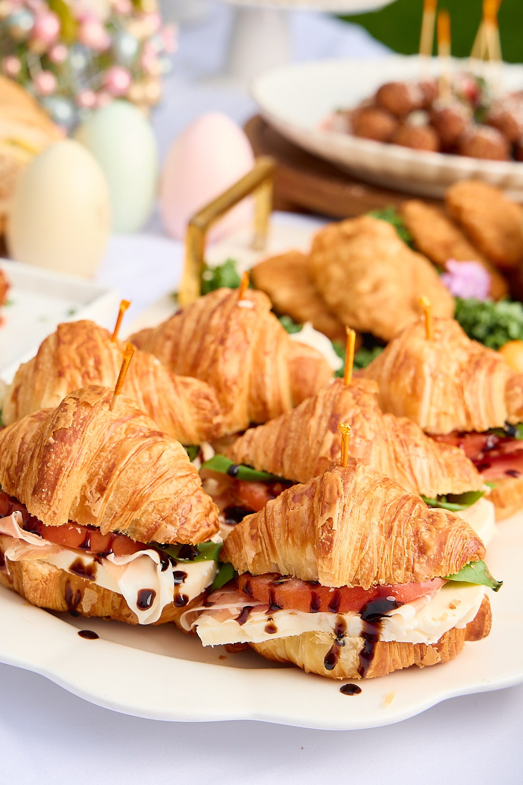 Italian sandwich platter with focaccia and prosciutto pieces on wooden boards.
